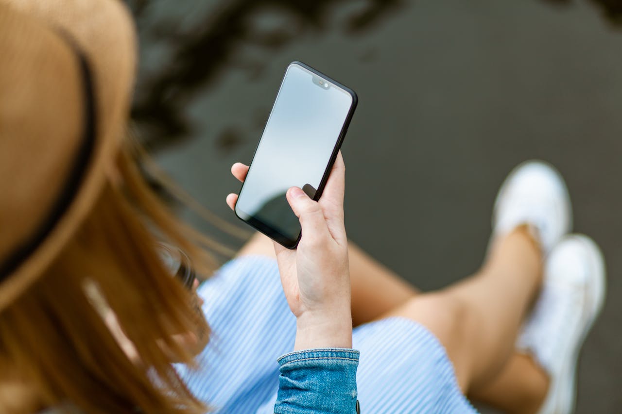 Frau blickt auf Smartphone Die Rolle der sozialen Medien bei der Gestaltung von Musiktrends