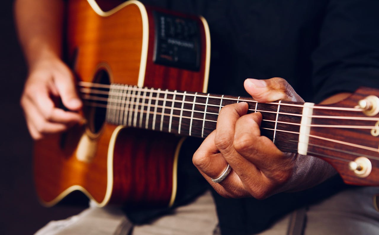 Mann spielt Gitarre kulturell divers Schöne Gitarrenmusik – Bands, Künstler und mehr