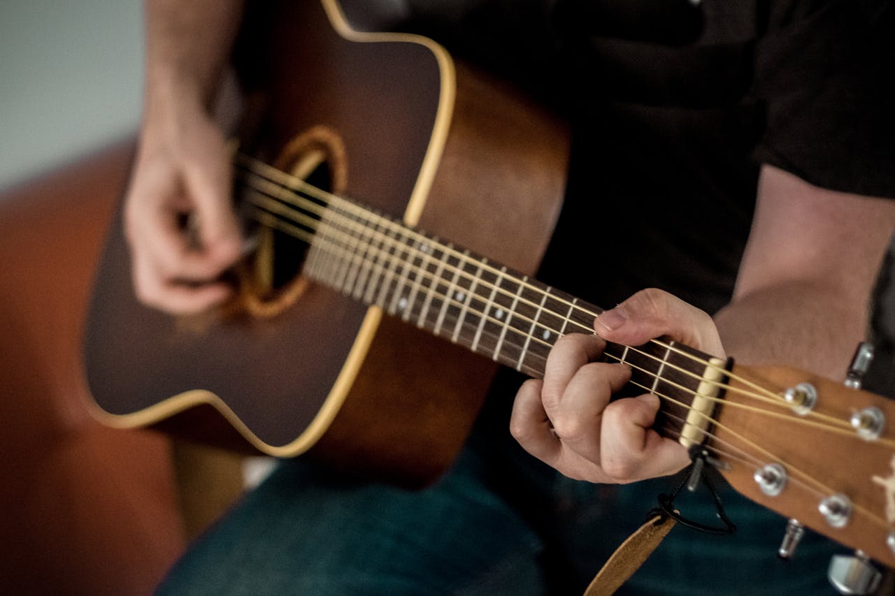 Mann spielt auf der Gitarre Gitarrenunterricht – Wann lohnt er sich